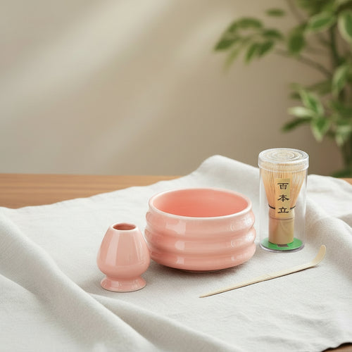 Tea set with pink ceramic bowl, small cup, and container on a white background